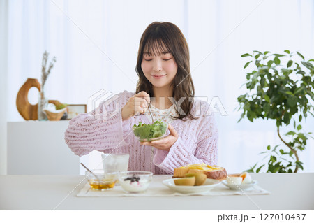 爽やかな初夏の朝に朝食を食べる女性 爽やかな初夏の朝に朝食を食べる女性 127010437