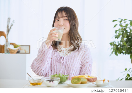 爽やかな初夏の朝に朝食を食べる女性 爽やかな初夏の朝に朝食を食べる女性 127010454
