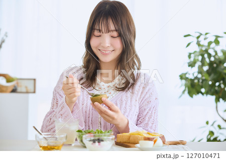 爽やかな初夏の朝に朝食を食べる女性 爽やかな初夏の朝に朝食を食べる女性 127010471