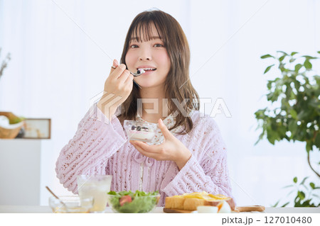 爽やかな初夏の朝に朝食を食べる女性 爽やかな初夏の朝に朝食を食べる女性 127010480