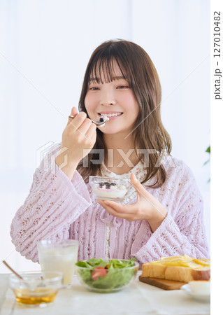 爽やかな初夏の朝に朝食を食べる女性 爽やかな初夏の朝に朝食を食べる女性 127010482