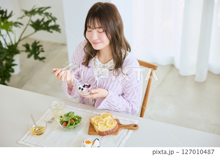 爽やかな初夏の朝に朝食を食べる女性 爽やかな初夏の朝に朝食を食べる女性 127010487