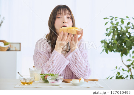 爽やかな初夏の朝に朝食を食べる女性 爽やかな初夏の朝に朝食を食べる女性 127010493