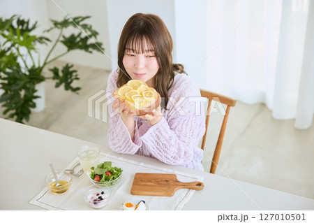 爽やかな初夏の朝に朝食を食べる女性 127010501