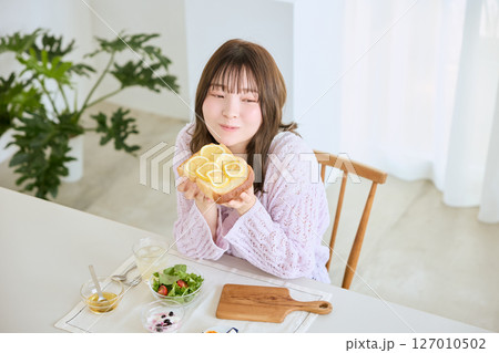 爽やかな初夏の朝に朝食を食べる女性 127010502
