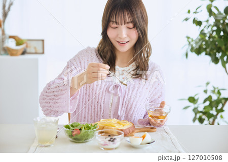 爽やかな初夏の朝に朝食を食べる女性 127010508