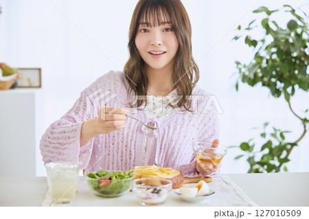 爽やかな初夏の朝に朝食を食べる女性 127010509