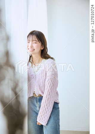 窓際でグラスに入ったジュースを飲む女性 127010724