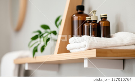 Spa treatment set, wooden shelf with neatly folded towels and dispensers for soap, cream, massage oil 127010764
