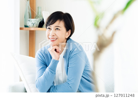 リビングでソファに座る中高年女性 リビングでソファに座る中高年女性 127011248