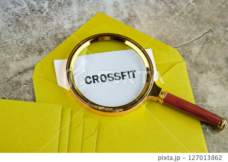 The concept of a healthy lifestyle. The word CROSSFIT through a magnifying glass on white paper, sticking out of a postal envelope 127013862