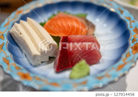 Fresh sashimi set with tuna, salmon, tofu and wasabi in a patterned ceramic dish Fresh sashimi set with tuna, salmon, tofu and wasabi in a patterned ceramic dish 127014456