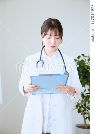 クリニックでカルテを書く女性医師 クリニックでカルテを書く女性医師 127014977