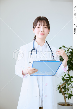 クリニックでカルテを書く女性医師 クリニックでカルテを書く女性医師 127014979