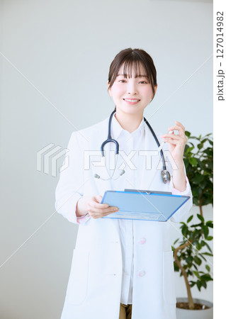 クリニックでカルテを書く女性医師 クリニックでカルテを書く女性医師 127014982
