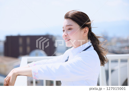 病院の屋上で空を見上げる女性医師 127015001