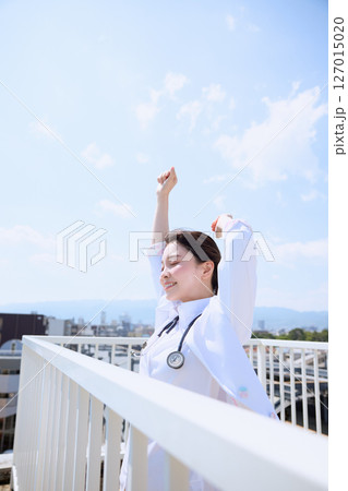 病院の屋上で空を見上げる女性医師 127015020