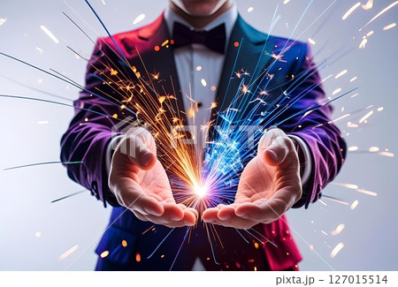 スーツに蝶ネクタイの男性の手から弾ける火花 スーツに蝶ネクタイの男性の手から弾ける火花 127015514