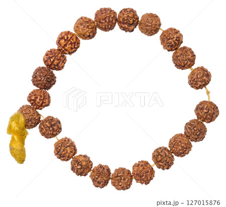 A Rudraksha bracelet made of brown beads with a yellow tassel, forming an open circle, isolated background 127015876