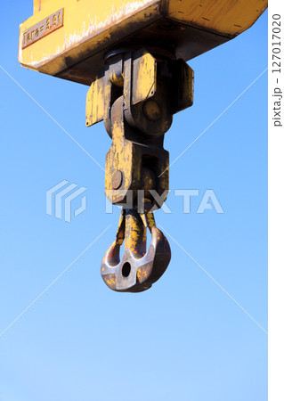 Crane hook at port area and blue sky 127017020