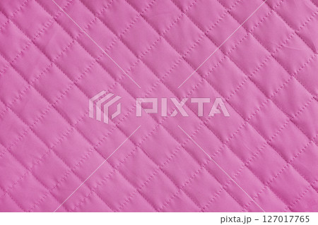 Checkered, diamond stitching pattern, pink quilted fabric background. Blanket stitch texture Checkered, diamond stitching pattern, pink quilted fabric background. Blanket stitch texture 127017765