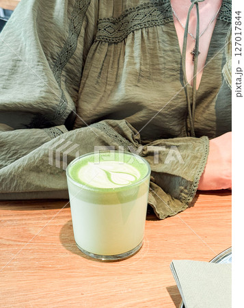 Green matcha latte close-up on wooden table. Drinks, modern lifestyle and coffee shop concept Green matcha latte close-up on wooden table. Drinks, modern lifestyle and coffee shop concept 127017844