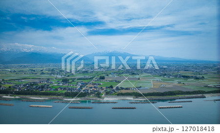 梅雨間際で湿度の高い日本の富山県沿岸部と周辺の離岸堤や洋上風力発電風車などの様子 127018418