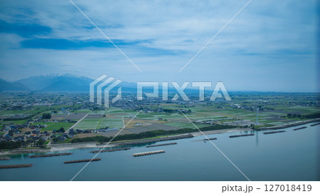 梅雨間際で湿度の高い日本の富山県沿岸部と周辺の離岸堤や洋上風力発電風車などの様子 127018419