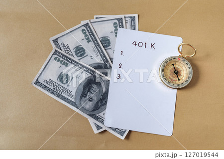 401k Plan and Gold compass on pile of US money. 401k Plan and Gold compass on pile of US money. 127019544