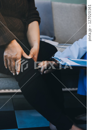 Young doctor examines senior patient's leg 127020161