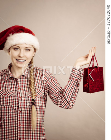 Happy shopping woman wearing Santa hat 127022040