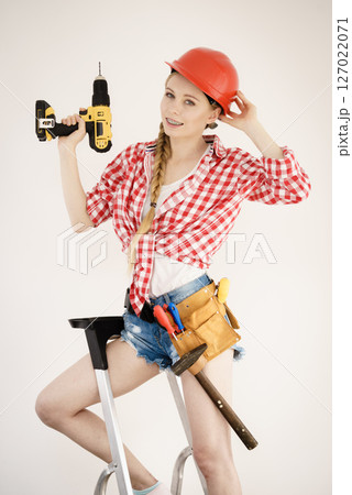 Girl using some power tools for work at home 127022071