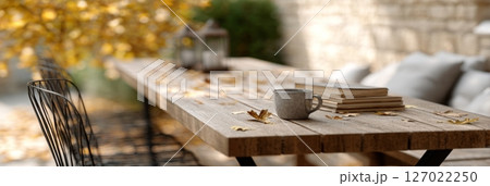 Enjoy a relaxing moment at an outdoor cafe terrace adorned with autumn leaves and warm beverages 127022250