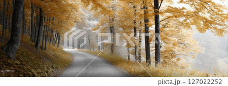 A serene road curves through a fall forest adorned with mist and golden leaves during early morning light 127022252