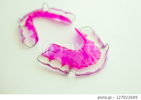 Pink acrylic dental retainer on white background Pink acrylic dental retainer on white background 127022689