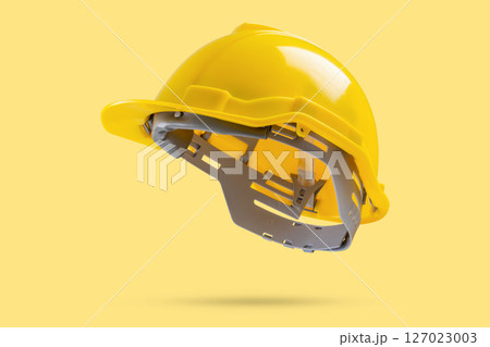 Safety construction helmet on yellow background 127023003
