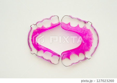 Pink acrylic dental retainer on white background 127023260