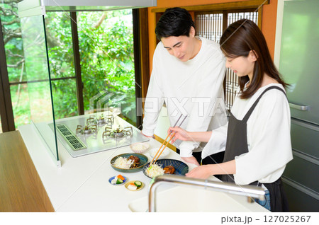 一緒に料理を作りながら笑顔を交わす男女の心温まる時間 127025267