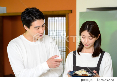 料理を一緒に見つめる男女の穏やかで温かな時間 127025278
