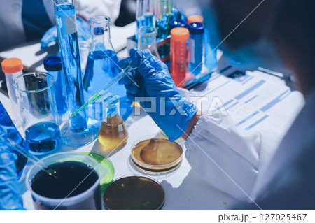 Scientist pipetting medical samples into microplate in laboratory 127025467