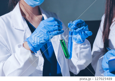 Scientist pipetting medical samples into microplate in laboratory 127025489