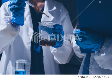 Scientist pipetting medical samples into microplate in laboratory 127025495