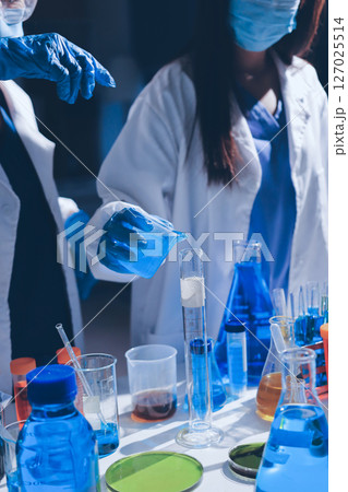 Scientist pipetting medical samples into microplate in laboratory 127025514