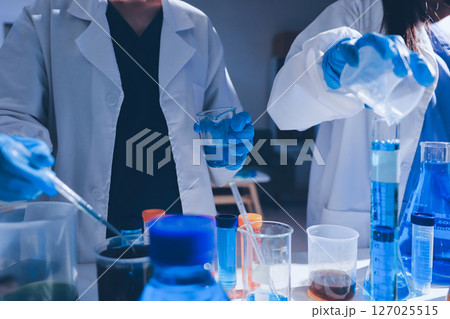 Scientist pipetting medical samples into microplate in laboratory Scientist pipetting medical samples into microplate in laboratory 127025515