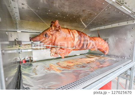 Barbecue with young pig grill Whole roasted piglet body turning on grill. Large barbecue in the process of cooking meat Barbecue with young pig grill Whole roasted piglet body turning on grill. Large barbecue in the process of cooking meat 127025670