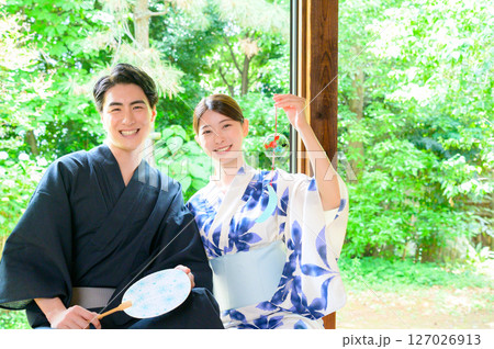 団扇を持つ浴衣姿の男女が縁側で見せる穏やかな夏の微笑み 団扇を持つ浴衣姿の男女が縁側で見せる穏やかな夏の微笑み 127026913