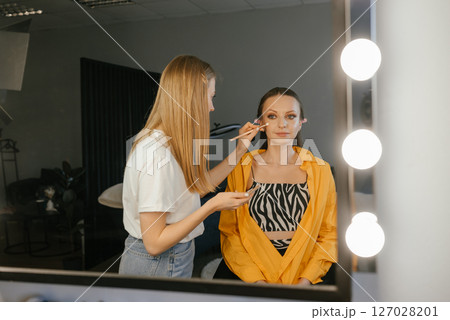 Makeup Artist Applying Eye Makeup in Professional Studio Makeup Artist Applying Eye Makeup in Professional Studio 127028201