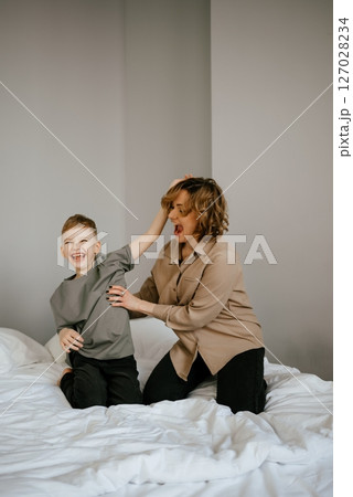 Mother and Son Laughing and Playing on Bed Mother and Son Laughing and Playing on Bed 127028234