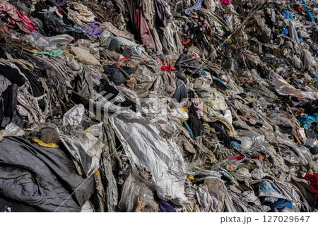 A sprawling landfill showcases a mixture of brightly colored fabrics and plastics piling up, highlighting ongoing pollution issues in the ecosystem A sprawling landfill showcases a mixture of brightly colored fabrics and plastics piling up, highlighting ongoing pollution issues in the ecosystem 127029647