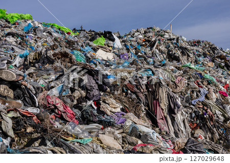 A vast accumulation of discarded clothing, plastic, and debris fills the landfill, highlighting urgent issues of pollution and waste management A vast accumulation of discarded clothing, plastic, and debris fills the landfill, highlighting urgent issues of pollution and waste management 127029648